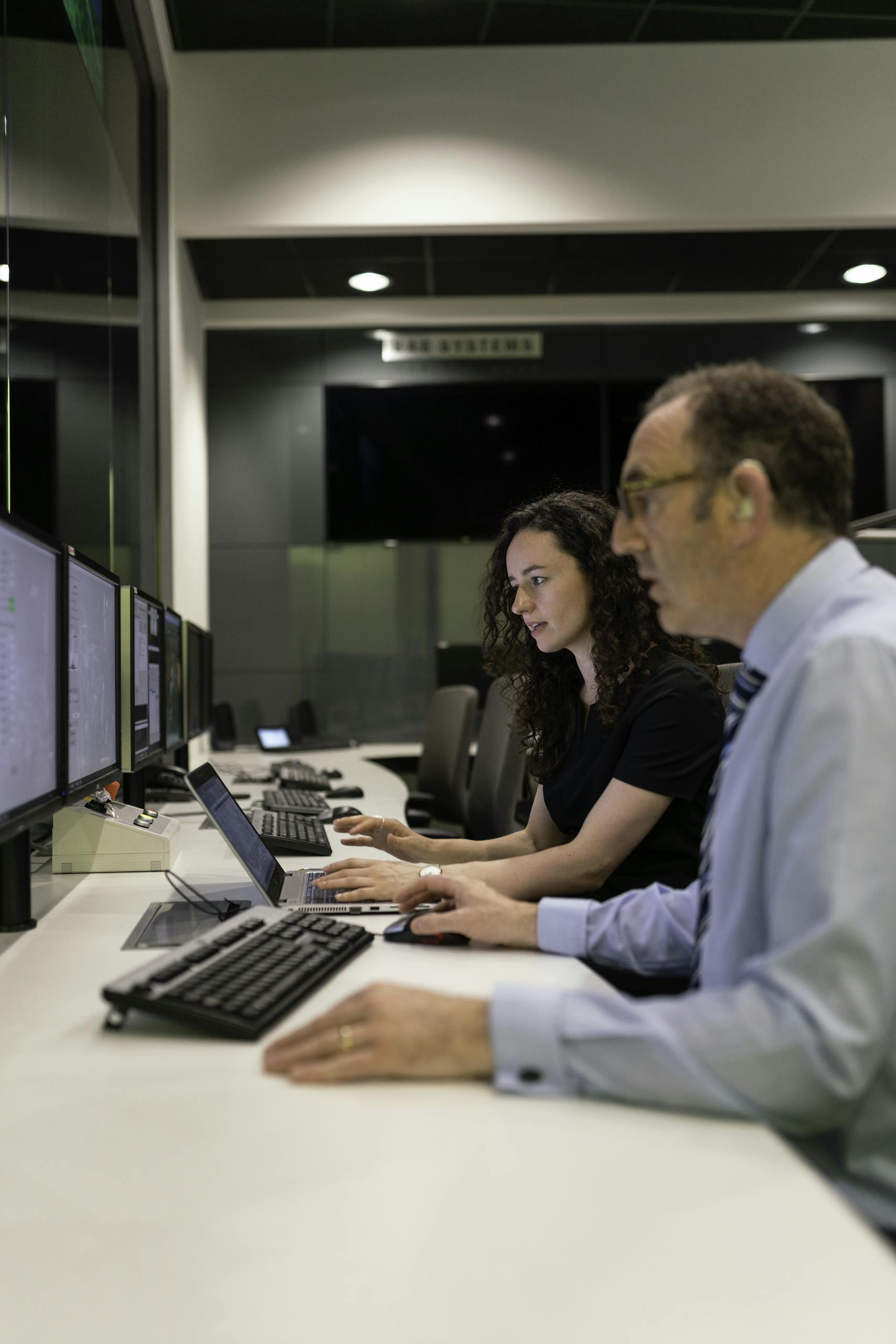 Engineers working together in a modern control room focused on simulation and testing.
