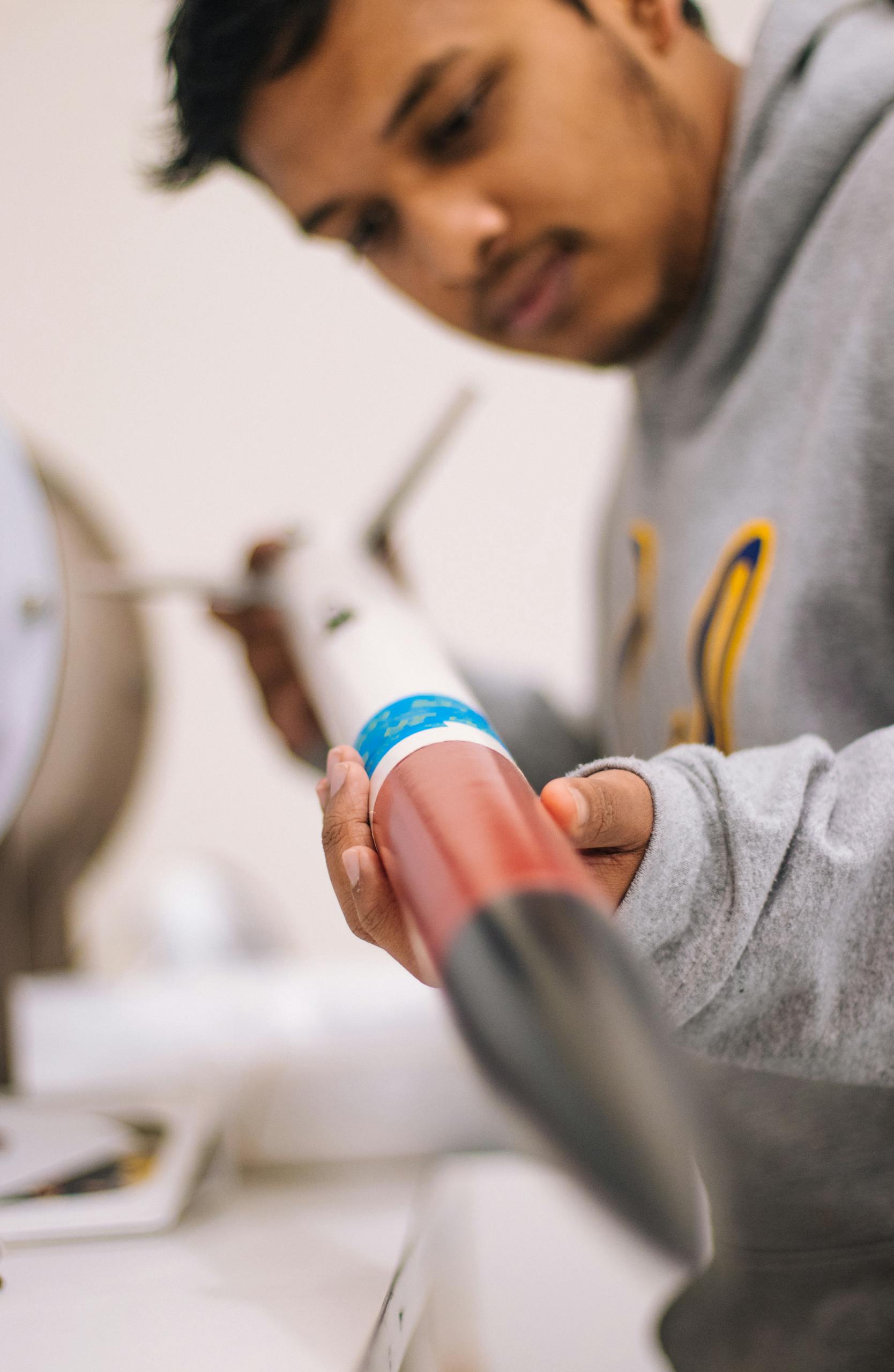 Harjai Foundation 1 Focused student inspecting a model rocket, emphasizing STEM learning and precision engineering.